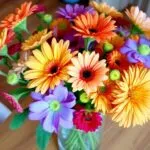 Colorful flowers in a glass vase on a table.