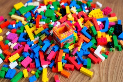 Colorful LEGO bricks on a wooden table with a structure.