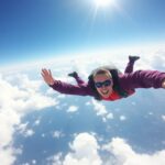 Skydiver freefalling through a clear blue sky.